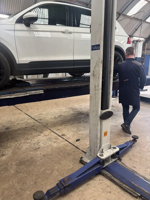 Monteur aan het werk onder een auto op de hefbrug bij A.S. Cars, april 2026
